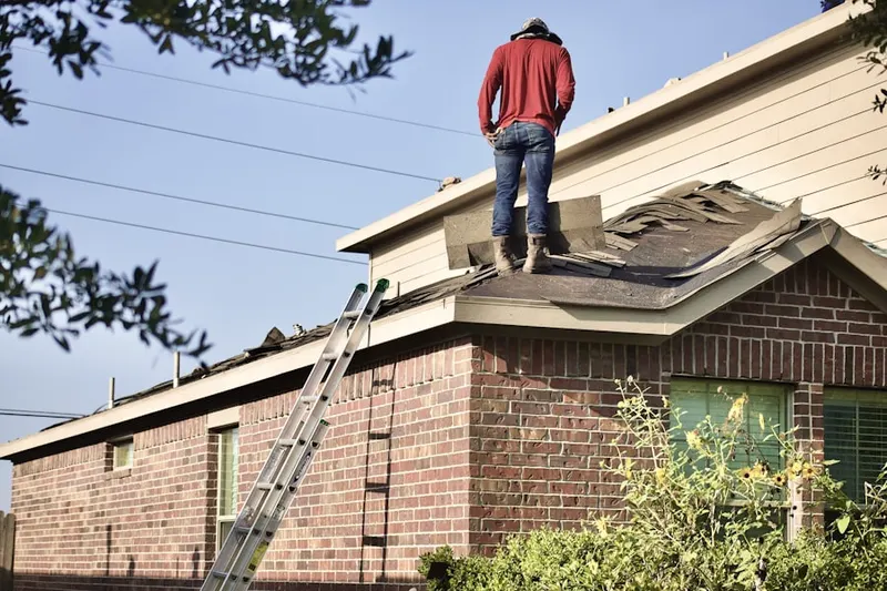 Professional roofer working on a residential roof in Moneta